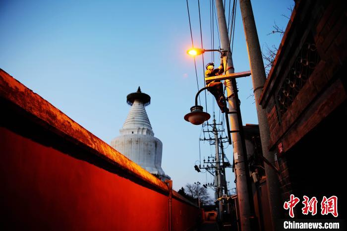 元旦前夕，北京城市照明管理中心员工检修维护白塔寺等地区照明设施。　张超 摄