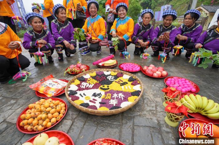 图为布依族妇女展示用于祭祀的花米饭。　贺俊怡 摄