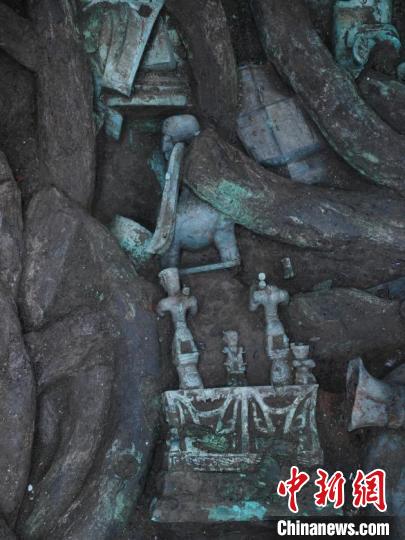 祭祀坑内，青铜神坛和其旁边的青铜神兽清晰可见。　四川省文物考古研究院供图