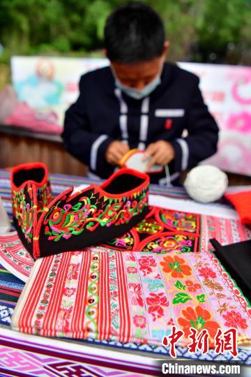 图为畲族非遗文化传承人在活动上展示传统畲族服饰制作技艺。　张斌 摄