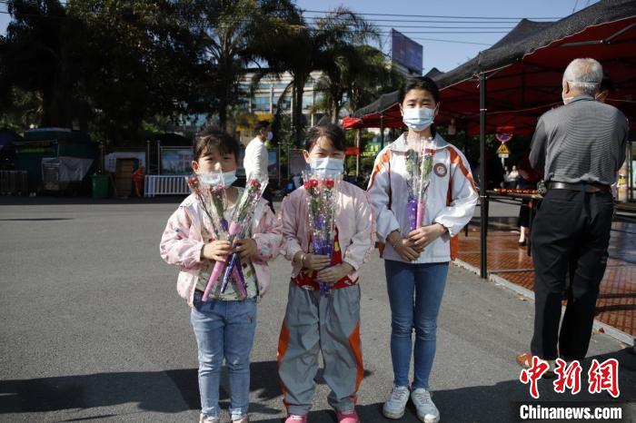 小朋友走出家门领取康乃馨。　陈雅芳 摄