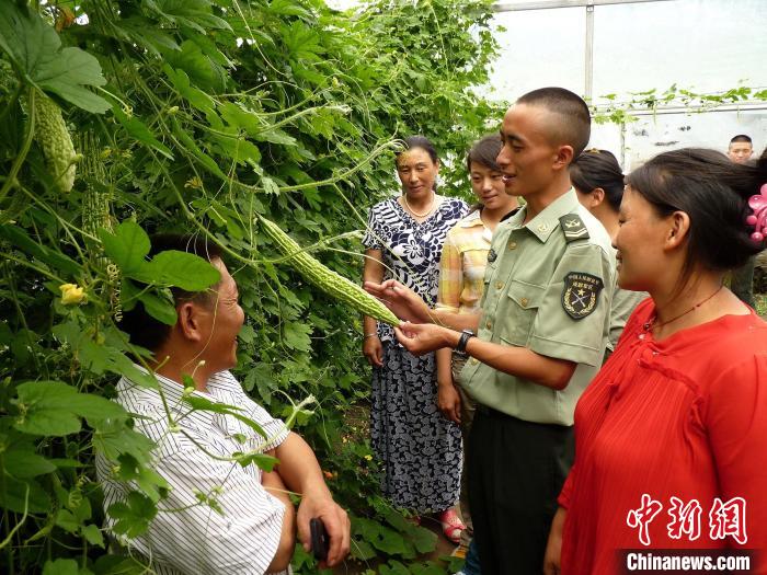 图为官兵向民众传授蔬菜种植技术。　马军 摄