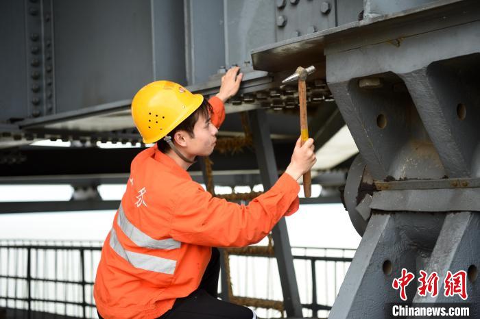 6月24日，南铁九江桥工段的桥梁工正在九景衢铁路鄱阳湖大桥上对高强度螺栓进行检查更换。　 黄旸 摄