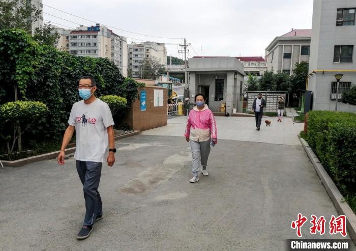 乌鲁木齐市沙依巴克区国道社区，市民保持距离在小区内散步。　钟欣 摄