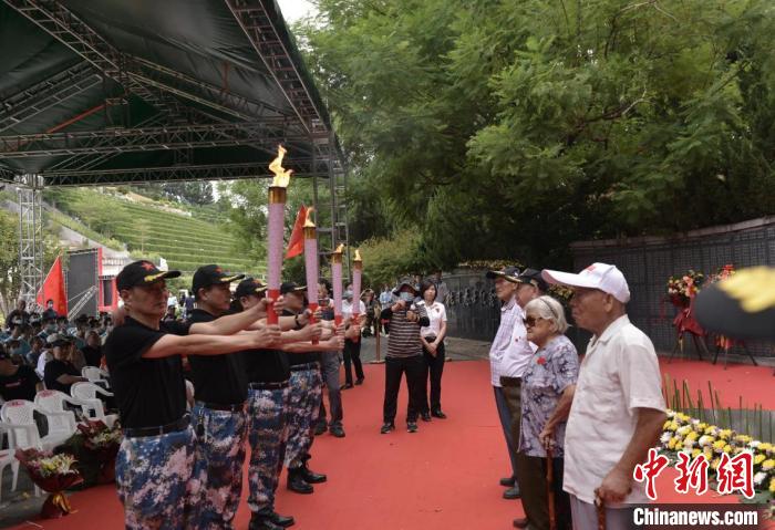 抗战志士后人从百岁老兵手中引燃火炬，点亮长明火。　钟欣 摄