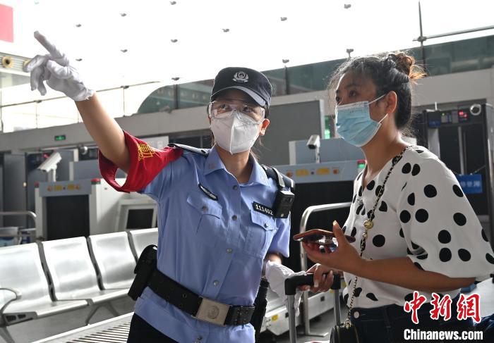 成都铁路公安处成都东车站派出所民警常琴茜在候车厅为旅客指引候车口。　安源 摄