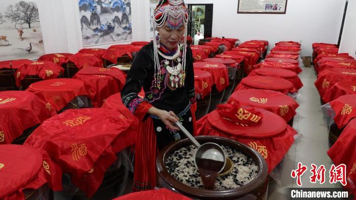 图为蓝春花在酒厂查看最新酿造的米酒。　记者华山 摄