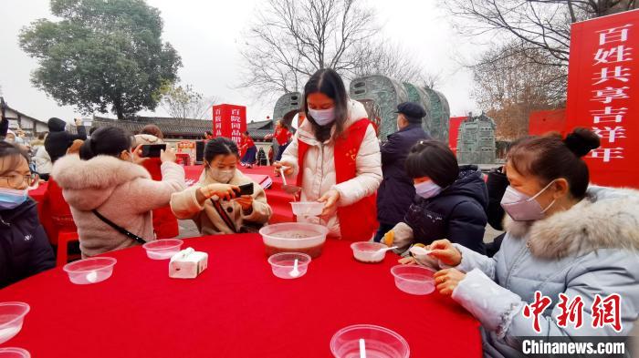 游客市民齐聚在一起，共品腊八粥。　王波 摄