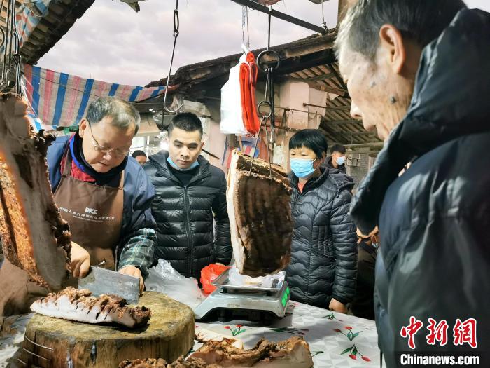 春节期间，台山四九镇五十墟老师傅黄长达的烧猪摊位上客似云来，烧猪是当地人开年饭的首选食材。　李晓春 摄