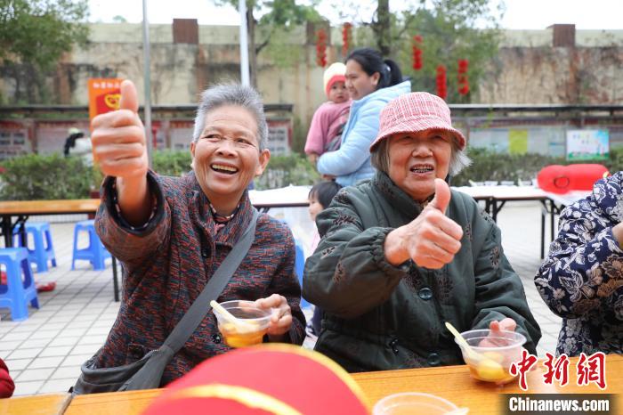 两位老人开心地吃着汤圆，并竖起大拇指。　黄晓君 摄