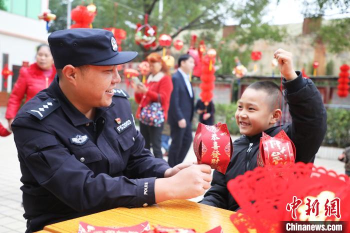 父子俩同时举灯笼，脸上洋溢着幸福的笑容。　黄晓君 摄