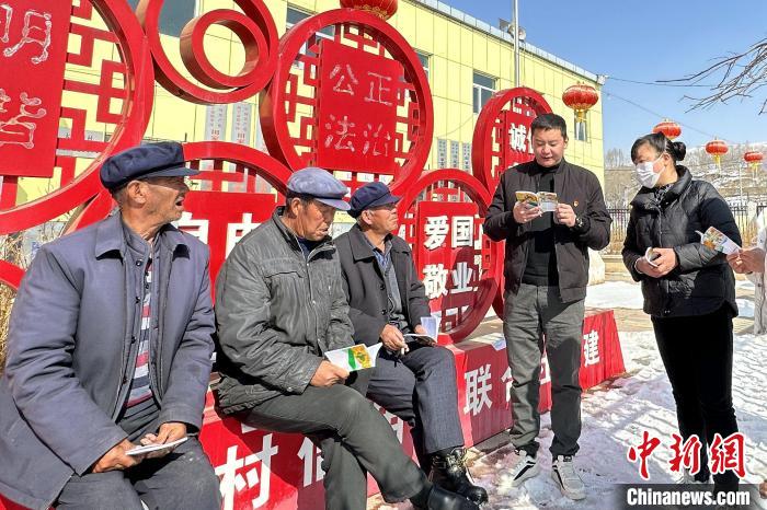 图为宣讲队员给村民宣讲中央一号文件。　湟中区田家寨正人民政府供图