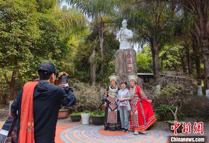 The picture shows tourists taking photos in front of the statue of 