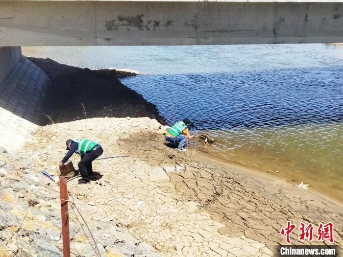 图为河南县河湖巡河员正在清理垃圾。　河南县委宣传部供图