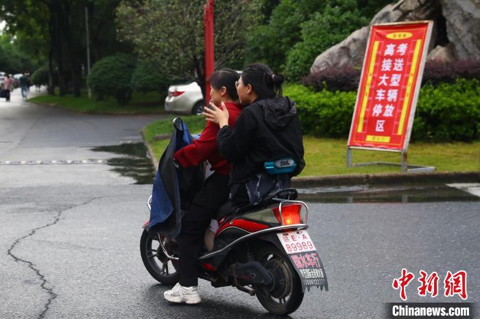 蒋张子怡和往常一样坐上母亲每日接送她的电动车回家。　刘占昆 摄