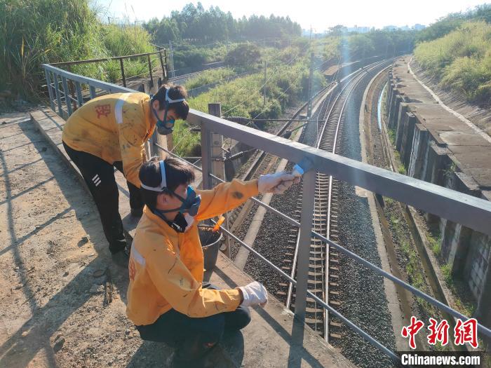 图为高温下南宁工务段桥梁工全副武装对铁路桥梁人行道栏杆打磨除锈。　冯博 摄