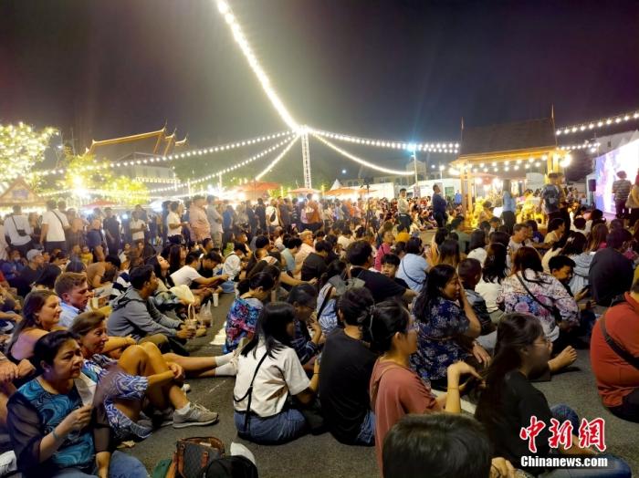 2023年12月31日晚，位于泰国曼谷湄南河畔的迎新年活动现场，各国游客席地而坐，等待新年零时的烟花燃放。中新社记者 李映民 摄