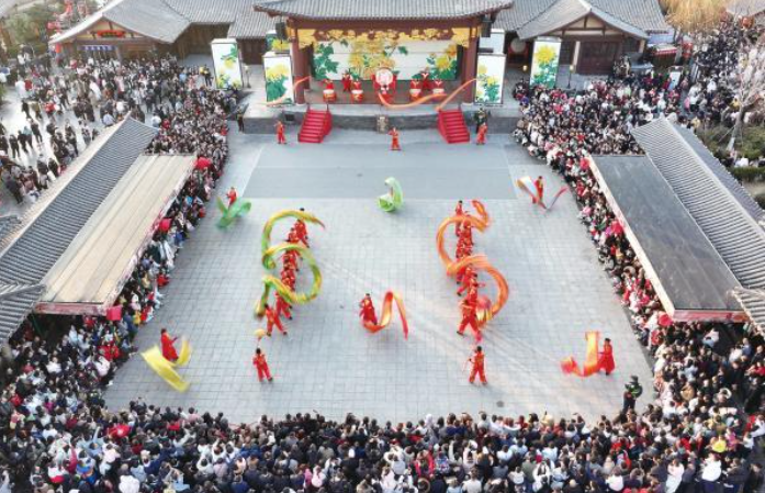 春节假期，各地纷纷“亮家底”“出大招”，举办丰富多彩的文旅活动，吸引市民和游客参观游览，体验十足年味。图为日前，游客在河南省开封市清明上河园景区观看表演。新华社发（谭豫增 摄）