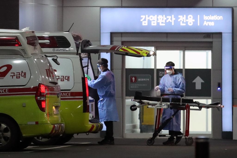 2022年3月22日，在韩国首尔，急救医疗中心医务人员对救护车和担架进行消毒。（图源：新华社）