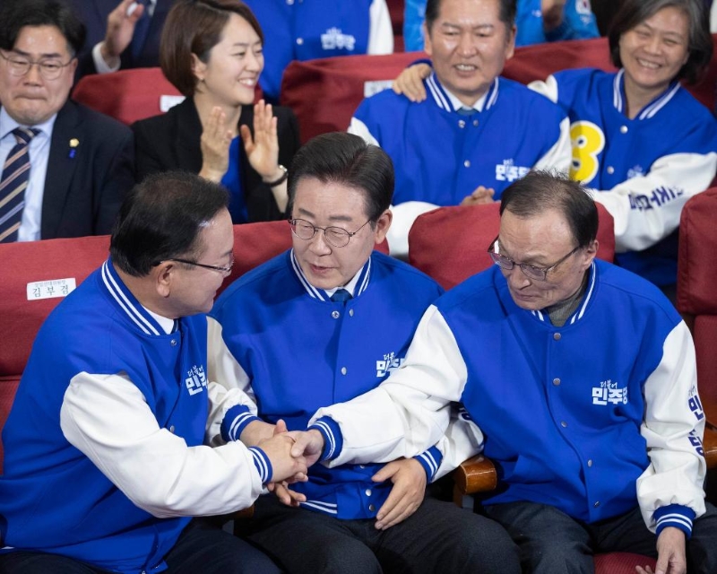 4月10日，在韩国首尔，韩国最大在野党共同民主党党首李在明（前排中）与共同民主党领导层共同庆祝出口民调结果大幅领先。（图源：新华社）